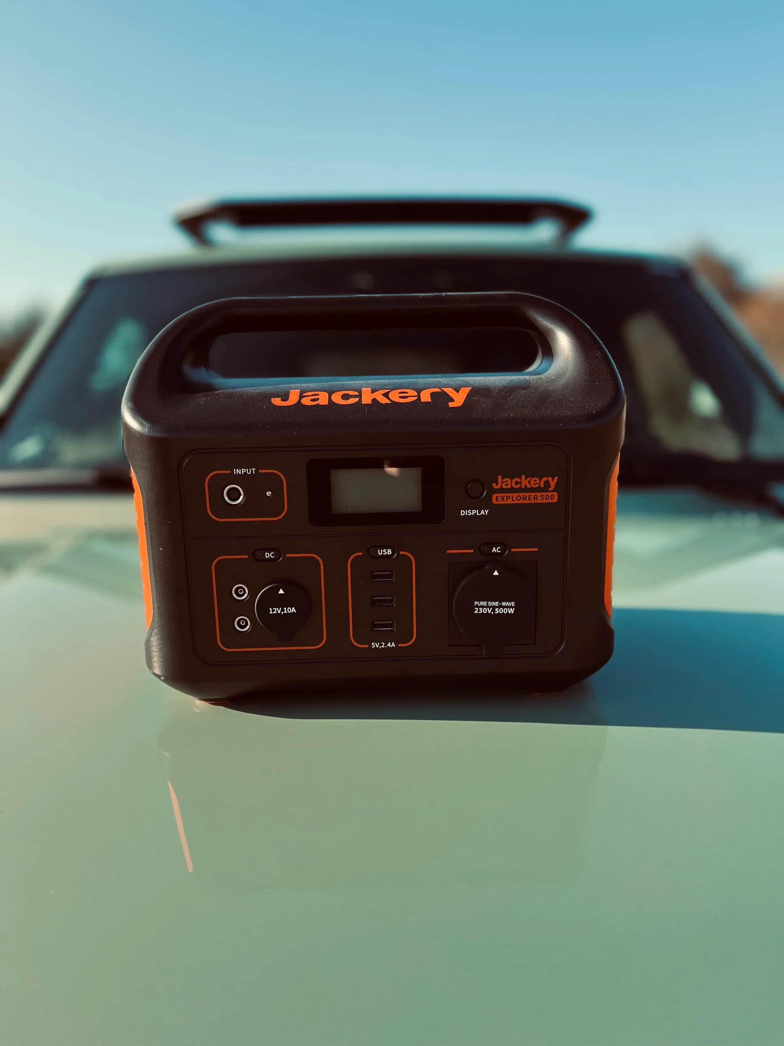 Sort Jackery-powerstation foran en bilrude.